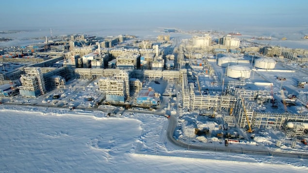 D'immenses réservoirs et autres installations pour l'exploitation du gaz naturel dans un désert blanc
