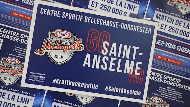 Une affiche promotionnelle pour la candidature de Saint-Anselme collée sur une vitre. 
