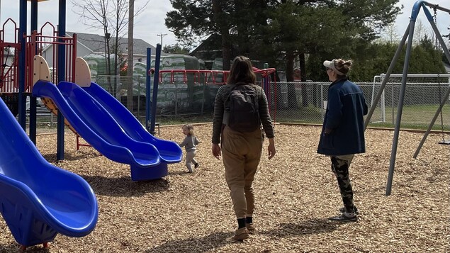 Une enfant et sa mère s'amusent dans un parc de jeux.
