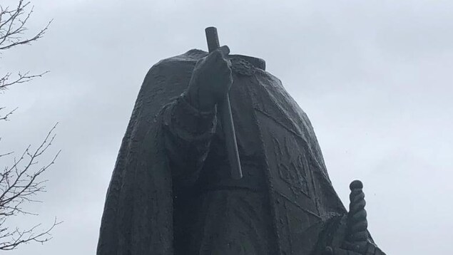 Une statue sans tête avec un ciel nuageux