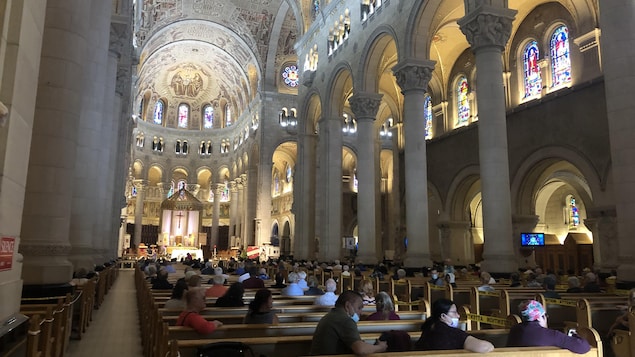 Plusieurs personnes sont assises à l'intérieur de l'église.