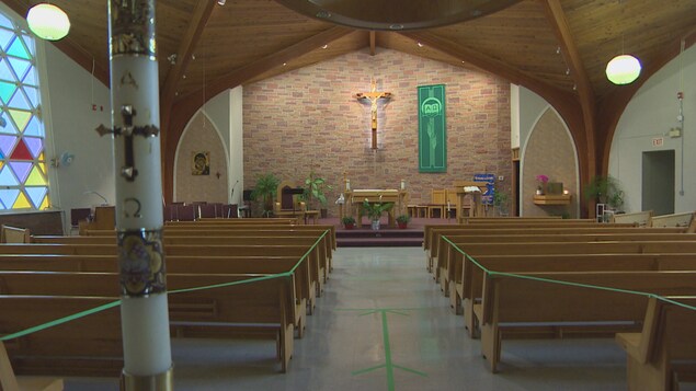 L'intérieur de la paroisse Saints-Martyrs-Canadiens de Saskatoon avec un ruban vert qui empêche les fidèles d'avoir accès à la plupart des bancs.