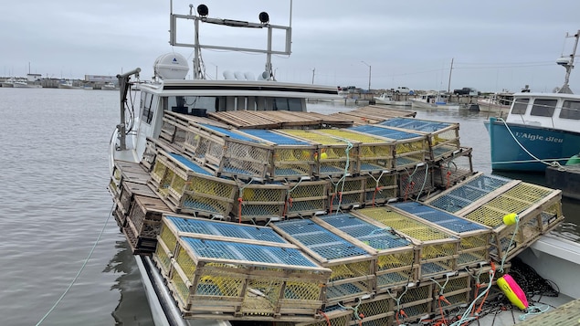 Un bateau rempli de casiers à homards dans le port de Baie Sainte-Anne.