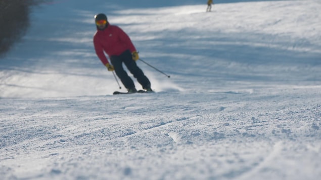 Un skieur en train de glisser sur une piste.