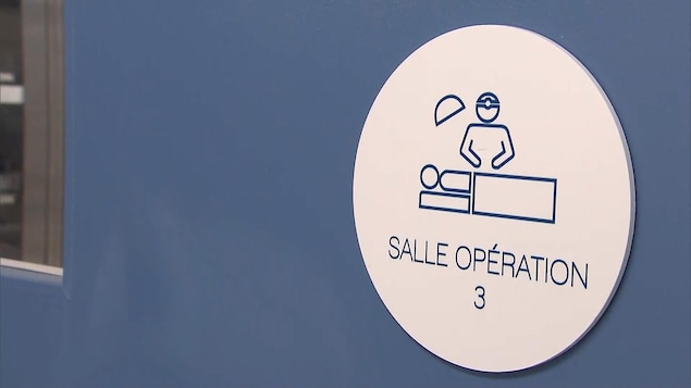 Une porte bleue avec une petite affiche sur laquelle on peut lire : salle opération 3 avec un icône