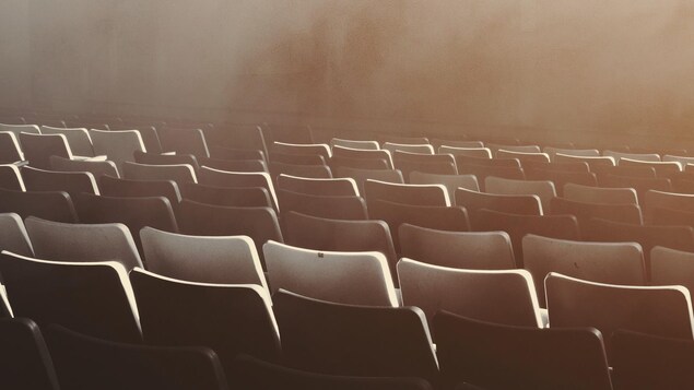 Des sièges vides dans une salle de spectacles.