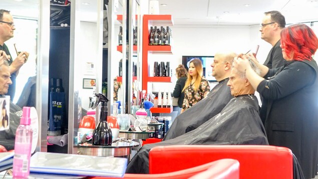 Des clients en train de se faire couper les cheveux dans un salon de coiffure de Québec Des clients en train de se faire couper les cheveux dans un salon de coiffure de Québec