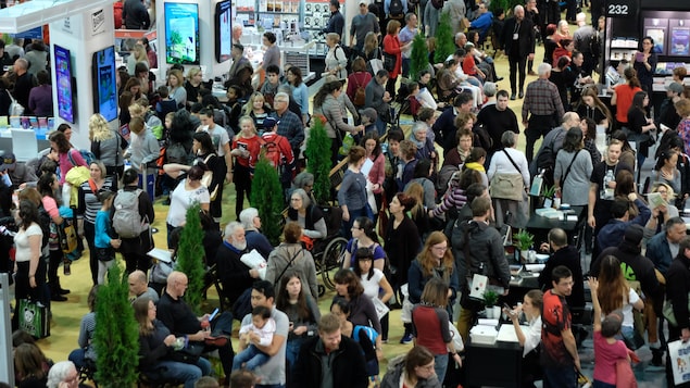 De nombreuses personnes se promènent dans les allées du Salon du livre. De nombreuses personnes se promènent dans les allées du Salon du livre.