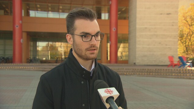 Un jeune homme répond aux questions d'un journaliste devant l'hôtel de ville d'Ottawa. Un jeune homme répond aux questions d'un journaliste devant l'hôtel de ville d'Ottawa.