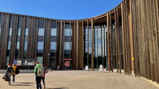People walk in front of a building. 
