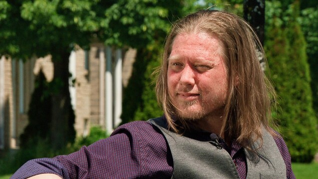 Un homme en entrevue à l'extérieur.