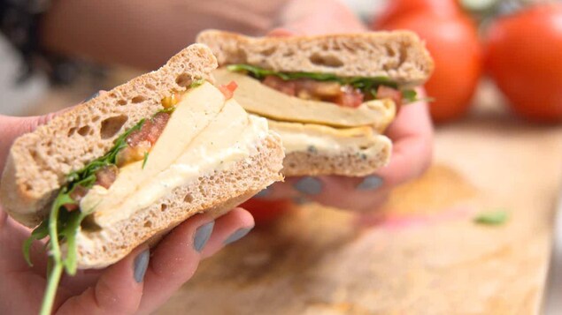 On voit un sandwich tranché, en gros plan.