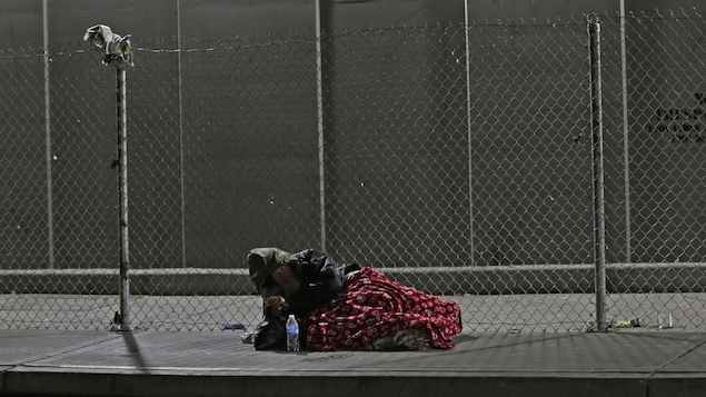 Un sans-abri qui dort sur le trottoir. Un sans-abri qui dort sur le trottoir.