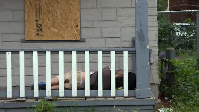 Un sans-abri dort sur la galerie d'une maison placardée de la rue Clarence.