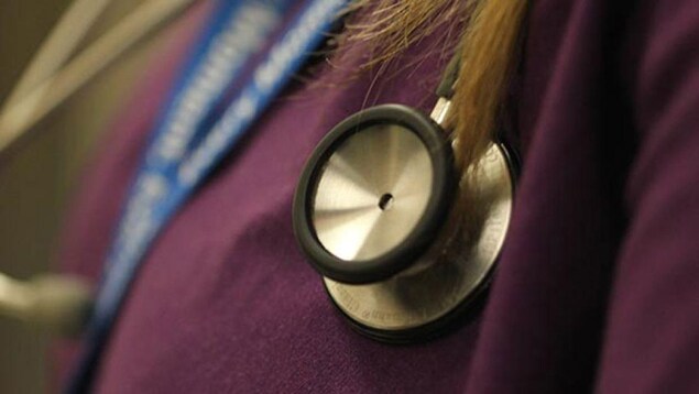 Un stétoscope sur la poitrine d'une femme qui porte un uniforme violet.
