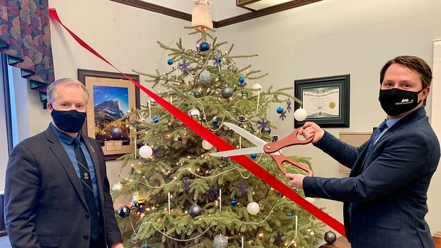 Le ministre associé de la Réduction de la bureaucratie, Grant Hunter, et le ministre de l'Agriculture et des forêts de l'Alberta, Devin Dreeshen, devant un sapin de Noël.