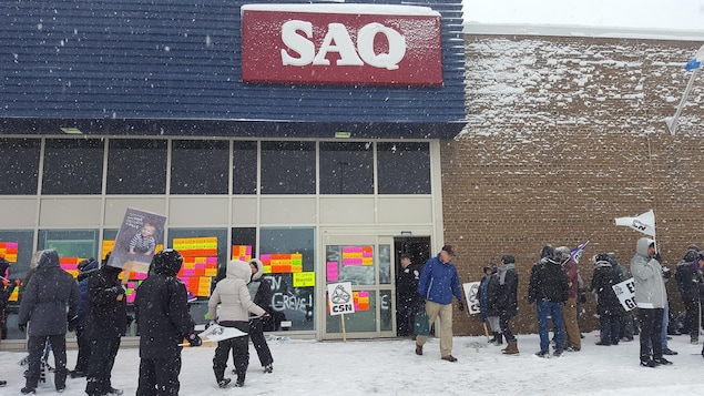 Des employés font du piquetage devant la succursale SAQ de Charlesbourg. Des employés font du piquetage devant la succursale SAQ de Charlesbourg.