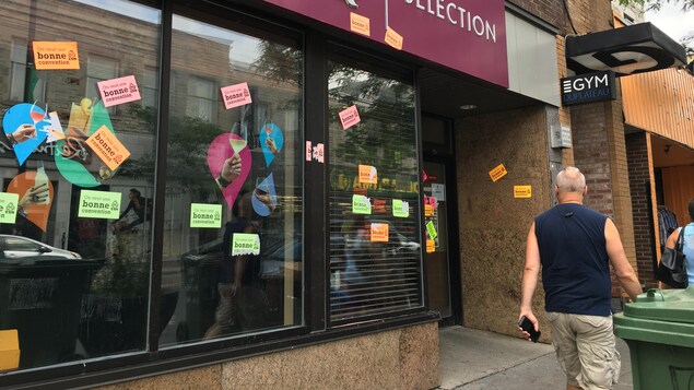Un passant circule devant une succursale de la SAQ dont la vitrine est placardée d'affichettes portant le message « On veut une bonne convention », à Montréal, au premier jour d'un débrayage des syndiqués