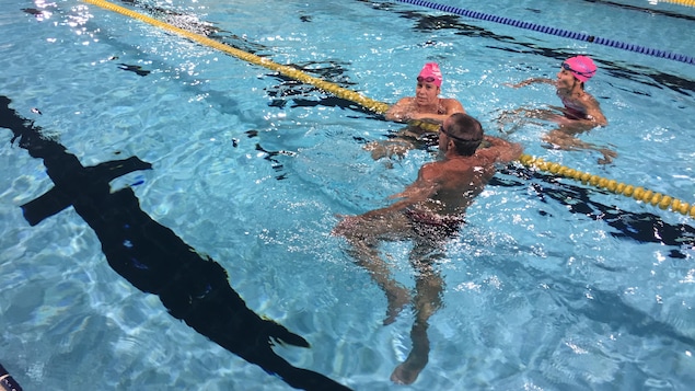 Deux femmes et un homme dans une piscine Deux femmes et un homme dans une piscine