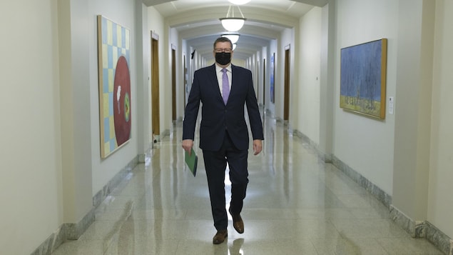 Le premier ministre de la Saskatchewan Scott Moe marche avec un masque.