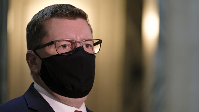 Scott Moe, pris de profil, en portant le masque à l'Assemblée législative de la Saskatchewan.