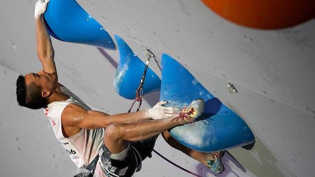 Sean McColl grimpe un mur à obstacle.