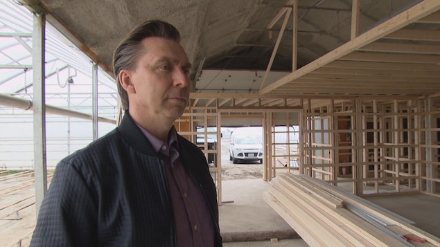 Un homme dans une serre en construction. Un homme dans une serre en construction.