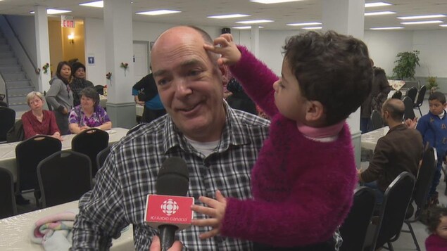 Sébastien Groleau porte un enfant dans ses bras pendant une entrevue.