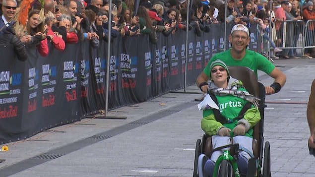 Le pédiatre Sébastien Roulier qui pousse une personne handicapée dans un chariot.