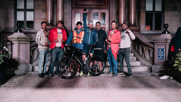 Un groupe pose devant un édifice imposant.
