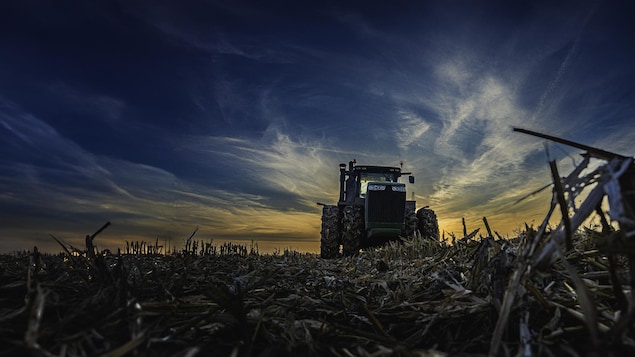 Un tracteur sur un champ sec.