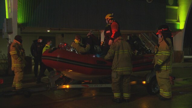 Des pompiers secourent un homme.