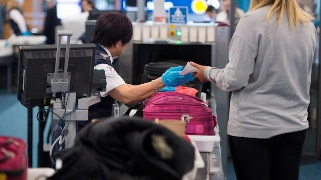 Des agents de la sécurité dans les aéroports fouillent les bagages à mains des passgers. Des agents de la sécurité dans les aéroports fouillent les bagages à mains des passgers.