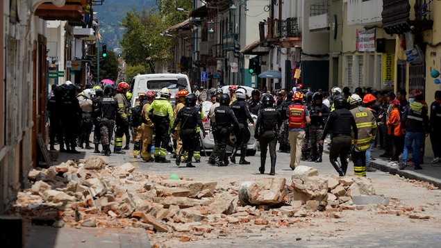 Une voiture endommagée et les décombres d'une maison endommagée par le tremblement de terre survenu à Cuenca, en Équateur.