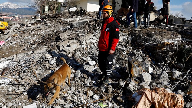 Un secouriste se tient au milieu des décombres et des dégâts causés par un tremblement de terre à Gaziantep, en Turquie, le 7 février 2023.