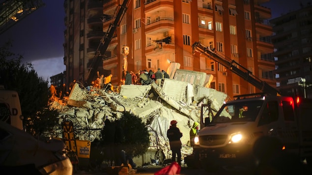 عمال الإنقاذ يبحثون ليلاً عن ناجين بين أنقاض أحد المباني في مدينة أضنة في جنوب تركيا.