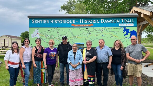 Des personnes devant une carte du Sentier Dawson, le 27 mai 2023.