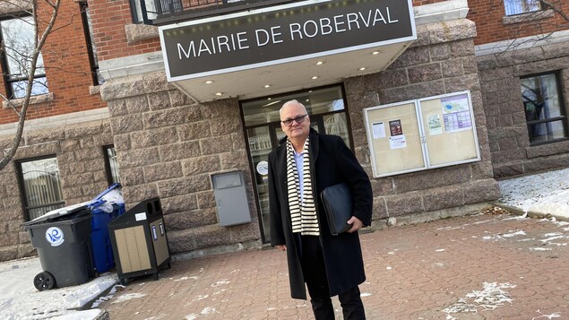 Un homme pose devant la mairie de Roberval 