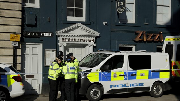 Quatre policiers discutent devant une camionnette de la police britannique stationnée devant le restaurant Zizzi. Quatre policiers discutent devant une camionnette de la police britannique stationnée devant le restaurant Zizzi.