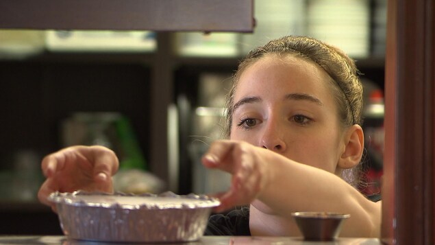 Une serveuse dépose un plat sur le comptoir.