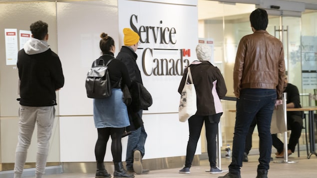 Des gens font la file dans un bureau gouvernemental.