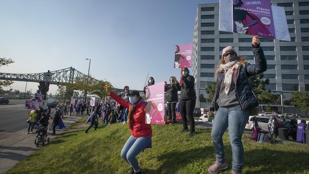 Des gens avec des pancartes manifestent.