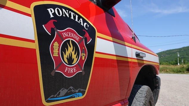 Une voiture rouge avec des lignes jaunes et blanches ainsi que l'écusson du Service de sécurité incendie de la Municipalité de Pontiac. 