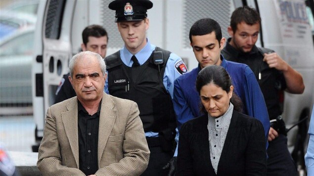 Les trois membres de la famille Shafia sont escortés par des policiers vers l'entrée du palais de justice de Kingston, le 20 octobre 2011.