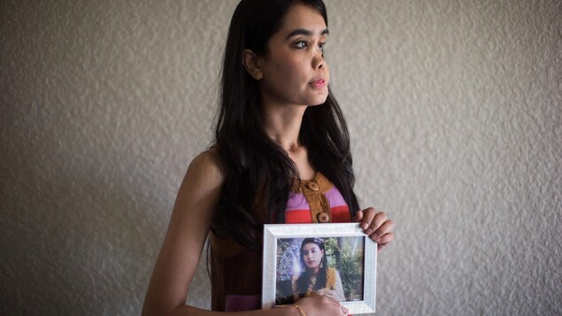 Shakila Zareen pose en tenant une photo montrant à quoi ressemblait son visage avant la tragique agression. Shakila Zareen pose en tenant une photo montrant à quoi ressemblait son visage avant la tragique agression.