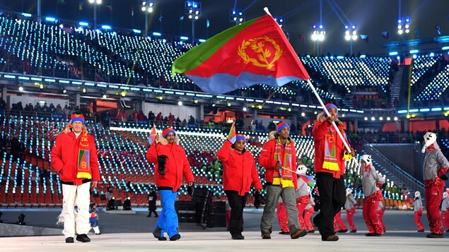 Pyeongchang, 9 février 2018. Shannon-Ogbani Abeda porte le drapeau de l'Érythrée lors de la cérémonie d'ouverture des Jeux olympiques de Pyeongchang. Il marche dans le stade suivi de 4 accompagnateurs de sa délégation. (Photo de Matthias Hangst/Getty Images) Pyeongchang, 9 février 2018. Shannon-Ogbani Abeda porte le drapeau de l'Érythrée lors de la cérémonie d'ouverture des Jeux olympiques de Pyeongchang. Il marche dans le stade suivi de 4 accompagnateurs de sa délégation. (Photo de Matthias Hangst/Getty Images)