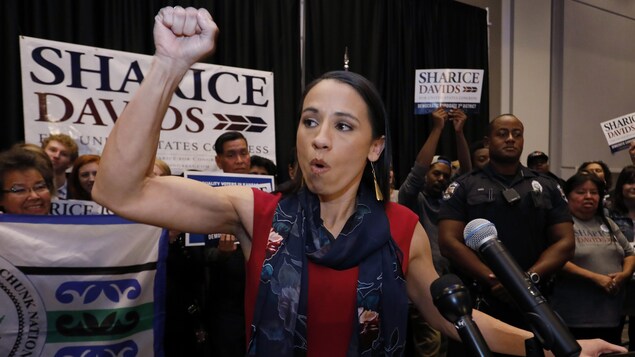 Sharice Davids lève le poing en l'air en s’adressant à ses partisans. Sharice Davids lève le poing en l'air en s’adressant à ses partisans.