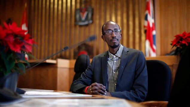 Un conseiller municipal assis à son bureau à la mairie.