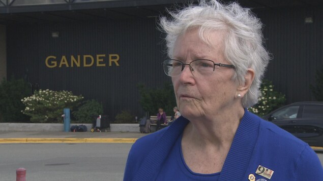 L'Américaine Shirley Brooks-Jones est devant un édifice où il est inscrit le nom de la ville, Gander.
