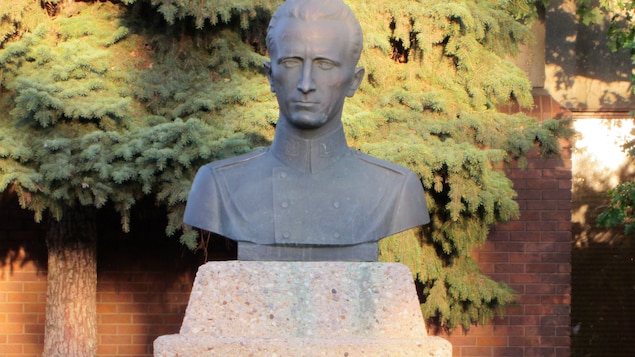 Un buste d'homme en uniforme militaire sur un monument.